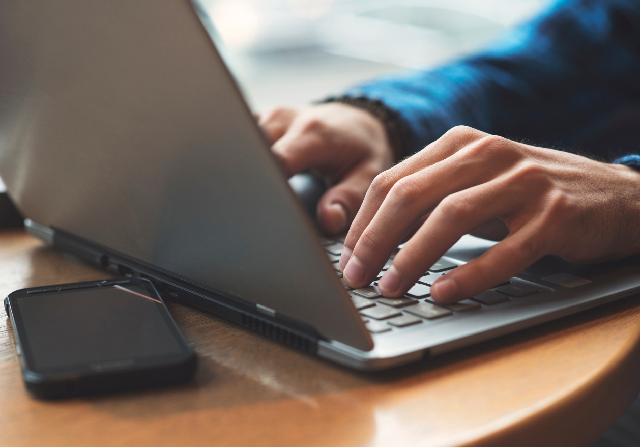 A man types on a laptop as he researches Defy Medical's privacy policy.